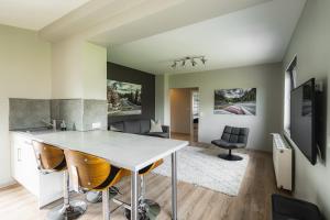a kitchen and living room with a table and chairs at NürbLife Hotel in Nürburg