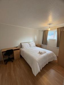 a bedroom with a white bed and a desk at Norwich Home in Norwich