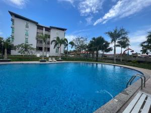 a large blue swimming pool in front of a building at SDC Suite Home 6 in Lahad Datu