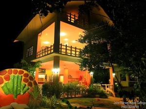 een groot huis 's nachts met de lichten aan bij Alexis Cliff Dive Resort in San Agustin