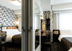 een hotelkamer met twee bedden en een badkamer bij APA Hotel Namba Shinsaibashi Nishi in Osaka