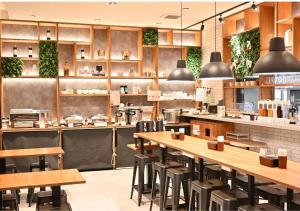 een restaurant met houten tafels en stoelen bij APA Hotel Namba Shinsaibashi Nishi in Osaka