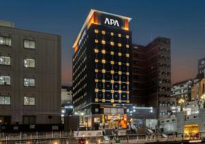 een hoog gebouw met een AC-bord bovenop. bij APA Hotel Namba Shinsaibashi Nishi in Osaka