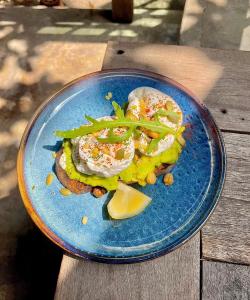 a blue plate with food on a wooden table at Paraiso Hotel Chiangmai in Chiang Mai