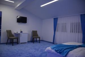 une chambre avec un lit et deux chaises et un bureau dans l'établissement Hotel Vrata Bosne, à Velika Kladuša