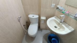 een badkamer met een wit toilet en een wastafel bij Hotel Golden Bird in Dhaka