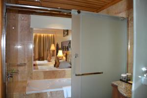 a bathroom with a bath tub and a bedroom at Angkorian Hostel in Phumi Ta Phul