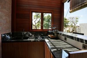 a bathroom with a sink and a window at HomeSix Bali in Uluwatu