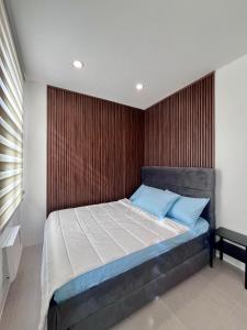 a bedroom with a large bed with a wooden wall at Vibe and Stay - Staycation home near Tagaytay in Calo