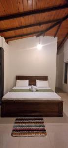 een groot bed in een kamer met een tapijt bij mountain retreat villa in Kandy