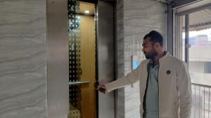 een man in een witte jas die een deur opent bij Hotel Golden Bird in Dhaka +36 foto's