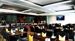 una sala da pranzo con tavoli e sedie in un ristorante di Amantis Hotel a Demak
