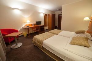 una camera d'albergo con letto e scrivania di Hotel Major Budget a Cracovia