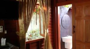 een badkamer met een raam, een toilet en een wastafel bij River Park Resort in Yan Ta Khao