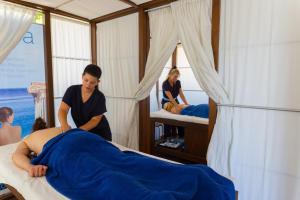 a woman in a room preparing a woman laying on a bed at Rethymno Mare Royal & Water Park in Skaleta