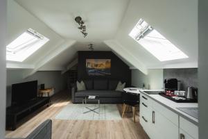 a living room with a couch and a kitchen with skylights at NürbLife Hotel in Nürburg