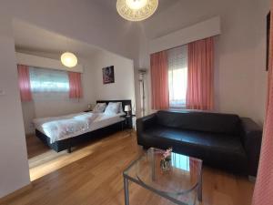 een woonkamer met een bed en een zwarte leren bank bij Hôtel Garni Inter-Alp in Saint-Maurice