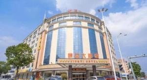 un grande edificio con auto parcheggiate di fronte di Guangzhou Jing Yi hotel a Huadu