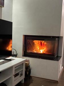a kitchen with a fireplace with a fire in it at Tarula Holiday Home in Melkoniemi