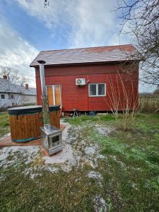 een rood huis met een kachel ervoor. bij Jövő Hét Pihenőház in Poroszló +17 foto's