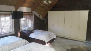 a bedroom with two beds and white cabinets at Do Drop In in Hoedspruit
