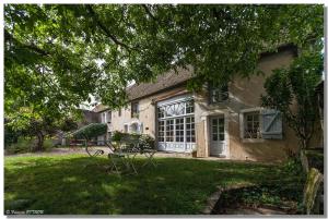 Corcelles-les-ArtsにあるLa Cuverie du Châteauの庭に大きな窓のある家