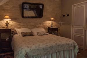 Corcelles-les-ArtsにあるLa Cuverie du Châteauのベッドルーム1室(ベッド1台、壁掛け鏡付)