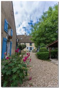 a house with pink flowers next to a building at La Cuverie du Château in Corcelles-les-Arts