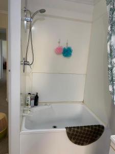 a bath tub with a shower and a sink at Seaview House Unit 2A in Whangarei