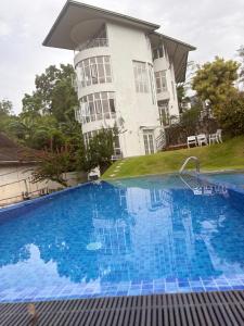 a house with a swimming pool in front of a house at Kandy krush Hotel in Kandy