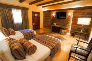 a hotel room with two beds and a television at The Old Village Hotel & Resort in Wadi Musa