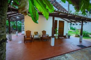 a patio of a house with chairs and a table at Rithu villa in Hikkaduwa