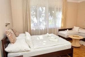 a bedroom with a bed and a couch and a window at Tompos Vendégház és pince in Villány