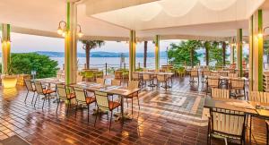 a restaurant with tables and chairs and a view of the water at Apartments Kanegra Plava Laguna in Umag