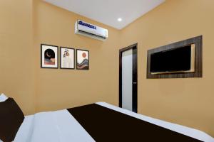 una camera da letto con un letto e una TV a schermo piatto di Hotel O Lotus Inn a Faridabad
