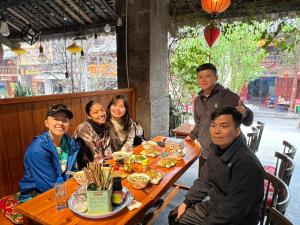 a group of people sitting at a table in a restaurant at Ha Giang SkyPath Hostel & Tours in Làng Lap