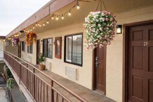 a balcony of a building with a door and flowers at San Francisco Inn in San Francisco