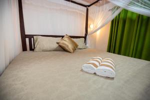 a bedroom with a bed with two slippers on it at Rithu villa in Hikkaduwa