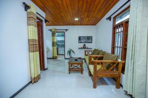 a living room with a couch and a table at Rithu villa in Hikkaduwa