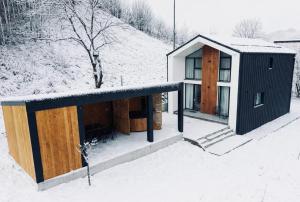 a house in the snow with a snow covered roof at Cozy HillSide in Borşa +18 photos