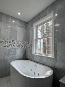 a bath tub in a bathroom with a window at Serene waterfront getaway in Mashpee +45 photos