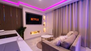 a living room with a couch and a tv at MagicSpa Gold in Chilly-Mazarin