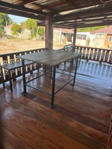 a picnic table on a wooden deck with chairs at NADOHN-Homestay in Ban Nam Lai Ta Tum
