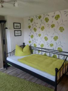 een slaapkamer met een bed met een groene deken bij Ferienhaus Scheper in Bad Frankenhausen