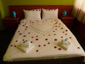 a bed with a heart made out of red flowers at Hotel Hubert Nové Zámky in Nové Zámky
