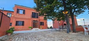 an orange building with a table and chairs in front of it at Villa Colli in Picciano