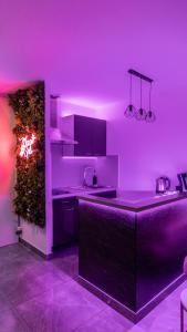 a kitchen with purple lighting and a kitchen counter at MagicSpa91 in Chilly-Mazarin
