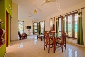 a dining room with a glass table and chairs at Celeste holiday homes in Calangute