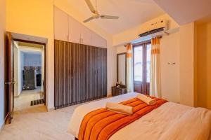 a bedroom with a large bed with an orange blanket at Celeste holiday homes in Calangute