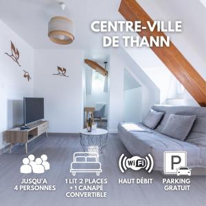 een woonkamer met een bank en een tv bij Appartement cosy centre historique in Thann